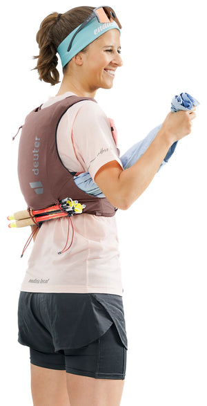 deuter Traick 5 SL running hydration vest in Raisin-Caspia worn by a woman on a neutral background.