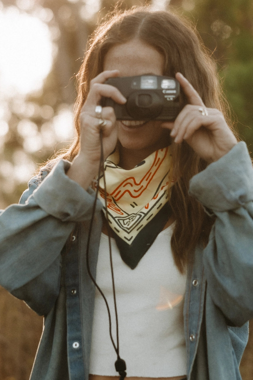 Bandits Grab The Horns bandana worn by a woman outdoors.