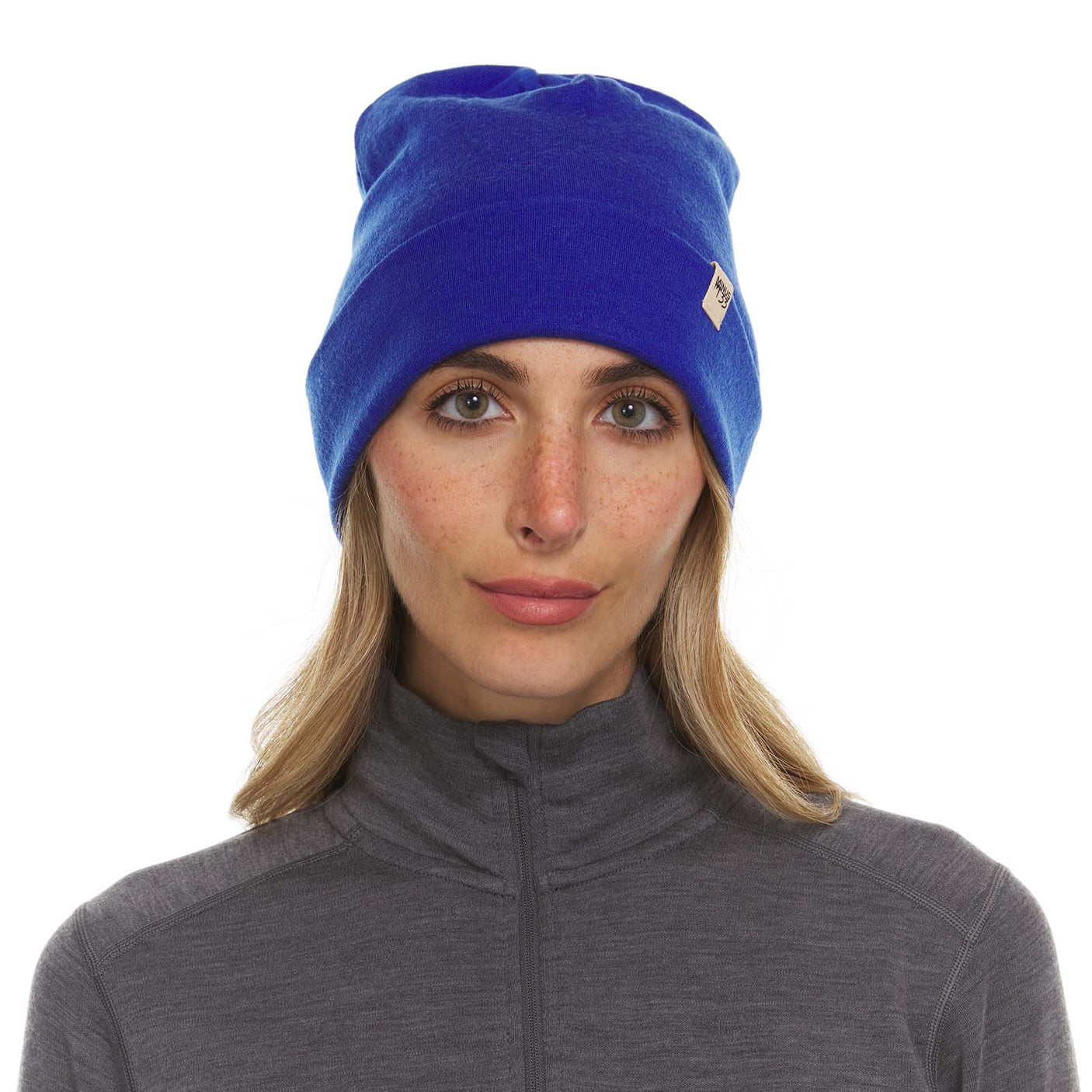 Minus33 Ridge Cuff Merino Wool Beanie in Royal Blue worn by a woman on a neutral background.