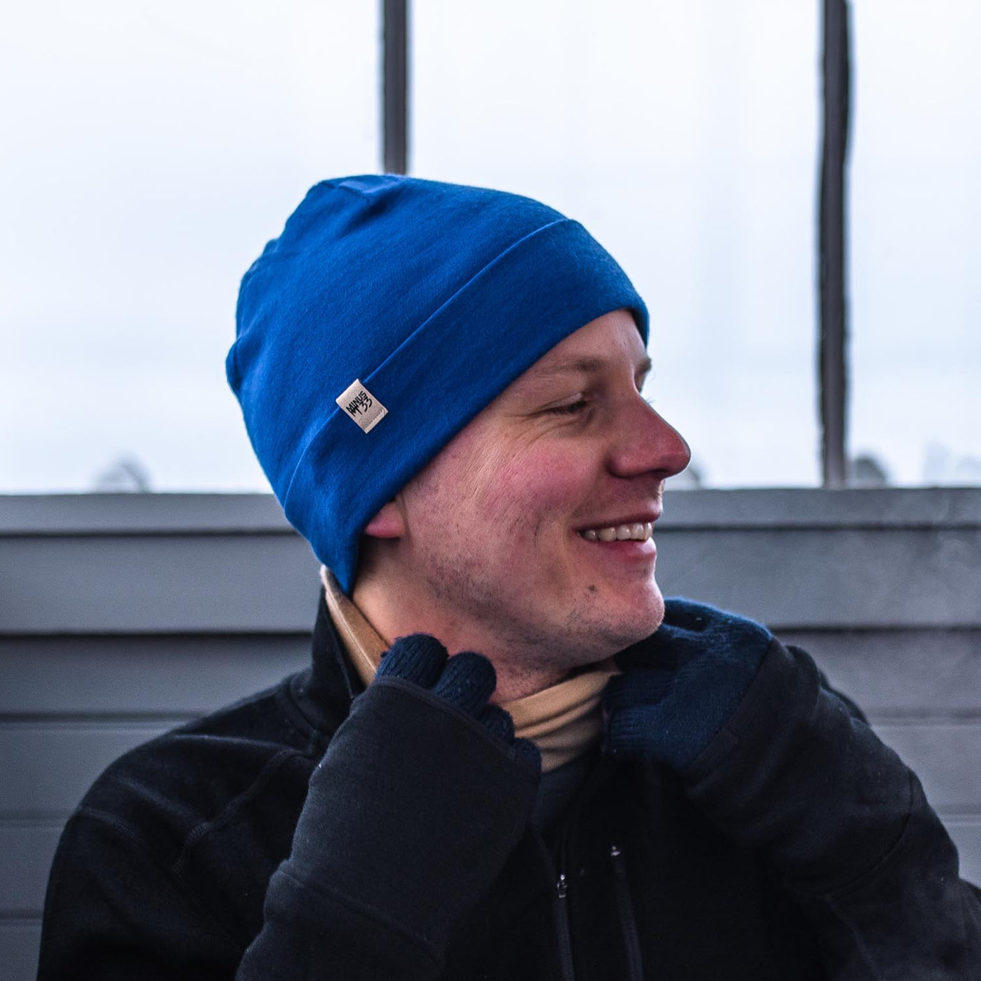 Minus33 Ridge Cuff Merino Wool Beanie in Royal Blue worn by a man outdoors.