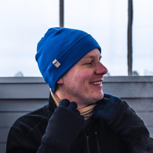 Minus33 Ridge Cuff Merino Wool Beanie in Royal Blue worn by a man outdoors.