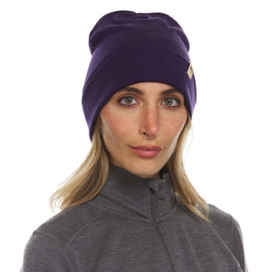 Minus33 Ridge Cuff Merino Wool Beanie in Dark Purple being worn by a woman on a neutral background.