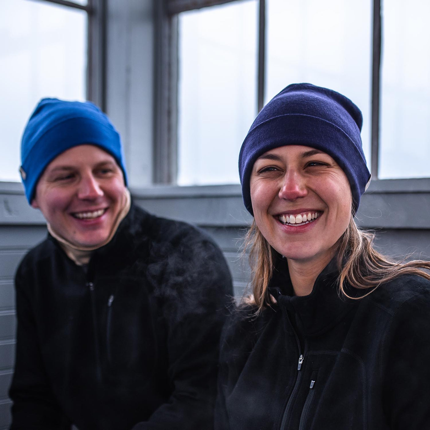 Minus33 Ridge Cuff Merino Wool Beanie in Dark Purple being worn by a woman outdoors.