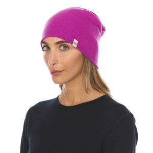 Minus33 Ridge Cuff Merino Wool Beanie in Radiant Violet being worn by a woman on a neutral background.