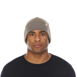 Minus33 Ridge Cuff Merino Wool Beanie in Tan 499 worn by a man on a neutral background.