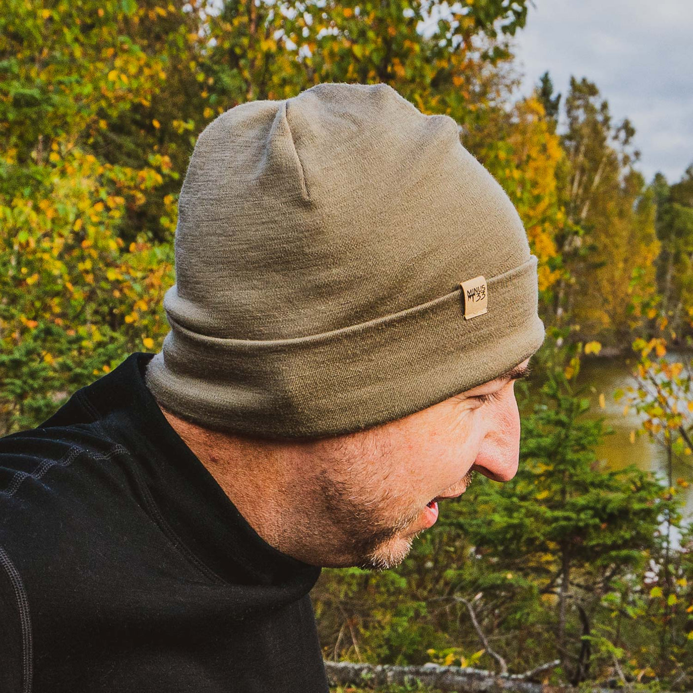 Minus33 Ridge Cuff Merino Wool Beanie in Tan 499 worn by a man outdoors.