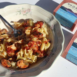 Ekone Mussels in Marinara with Capers tinned seafood in a bowl of pasta.