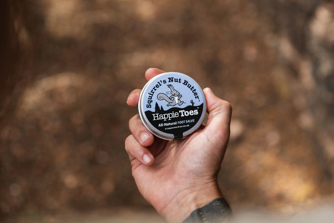 Squirrel's Nut Butter Happie Toes tin, showcasing product design and logo, intended for foot care and comfort.