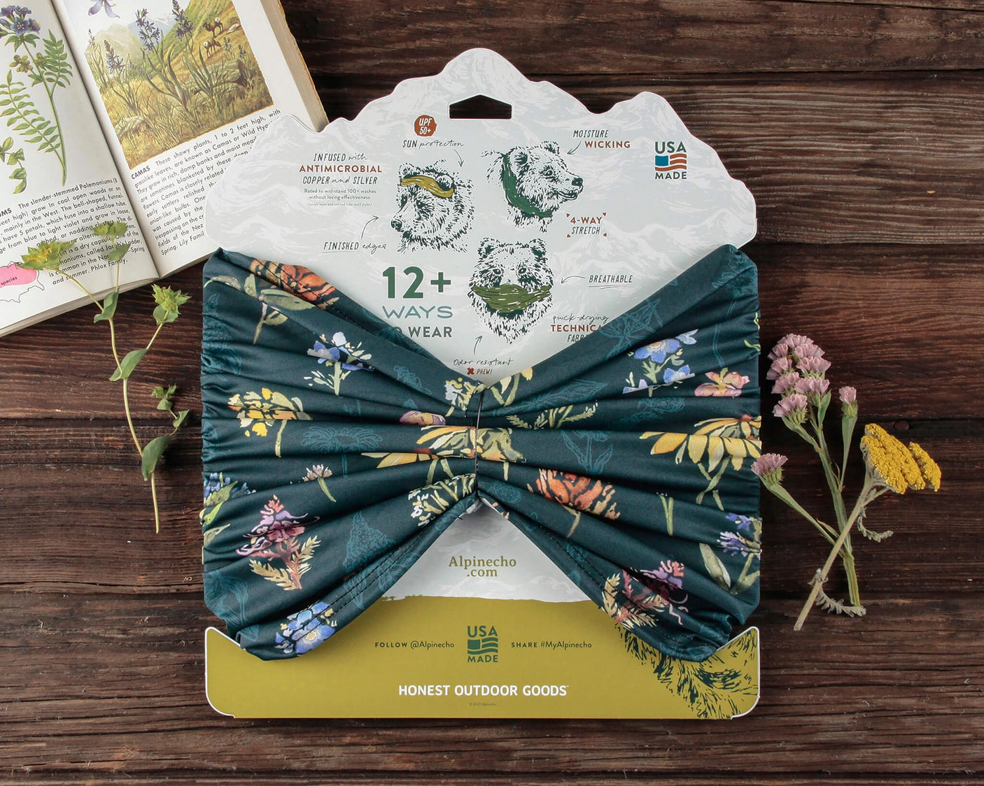 Alpinecho's Wildflowers Neck Gaiter packaged on a dark wood background.