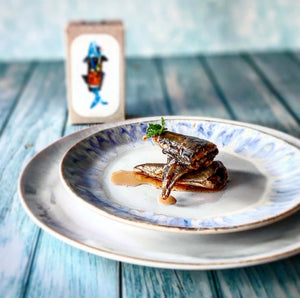 Jose Gourmet Stickleback in Pickled Sauce on a decorative plate with a blue wooden background