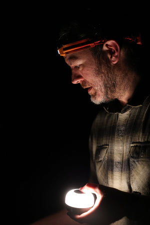 BioLite AlpenGlow Mini Lantern being handheld by a man.