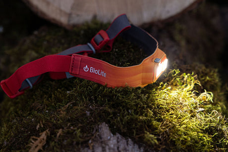 BioLite HeadLamp 425 in Ember Yellow on a mossy log.