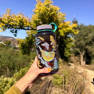 Mustard Beetle 32oz Nalgene bottle with the Prairie Warbler design, featuring a bird and flowers on a lavender colored Nalgene bottle.