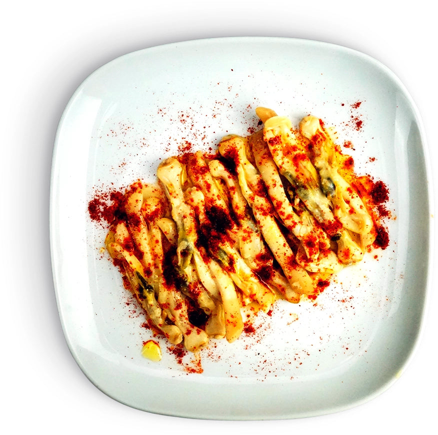 Plated dish of La Narval Galician Razor Clams in Brine with red sauce on a white plate