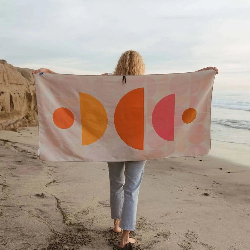 Trek Light Half Moon Wander towel is made from recycled plastic bottles and features a colorful half moon pattern.