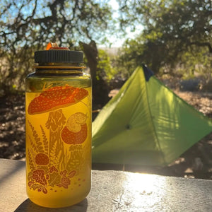 Mustard Beetle 32oz Nalgene bottle with the Toad & Mushrooms print features an orange and yellow print on a brown Nalgene bottle.