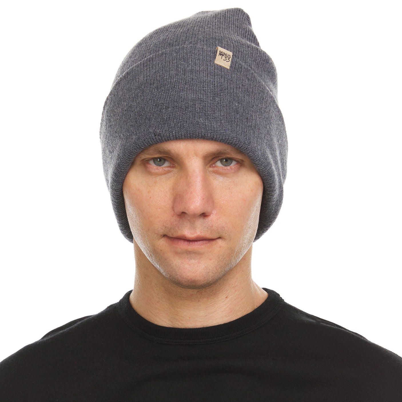 Minus33 Everyday Knit Cuff Merino Wool Beanie in Charcoal Gray being worn on a neutral background.