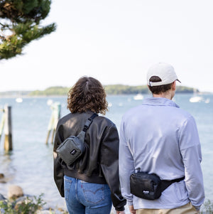 Flowfold Explorer Pack Small, made in the USA, worn by two people near a lake.