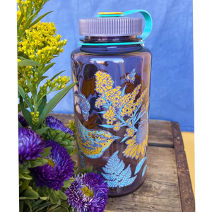 Mustard Beetle 32oz Nalgene bottle with the Prairie Warbler design, featuring a bird and flowers on a lavender colored Nalgene bottle.