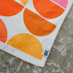 Trek Light Half Moon Wander towel is made from recycled plastic bottles and features a colorful half moon pattern.