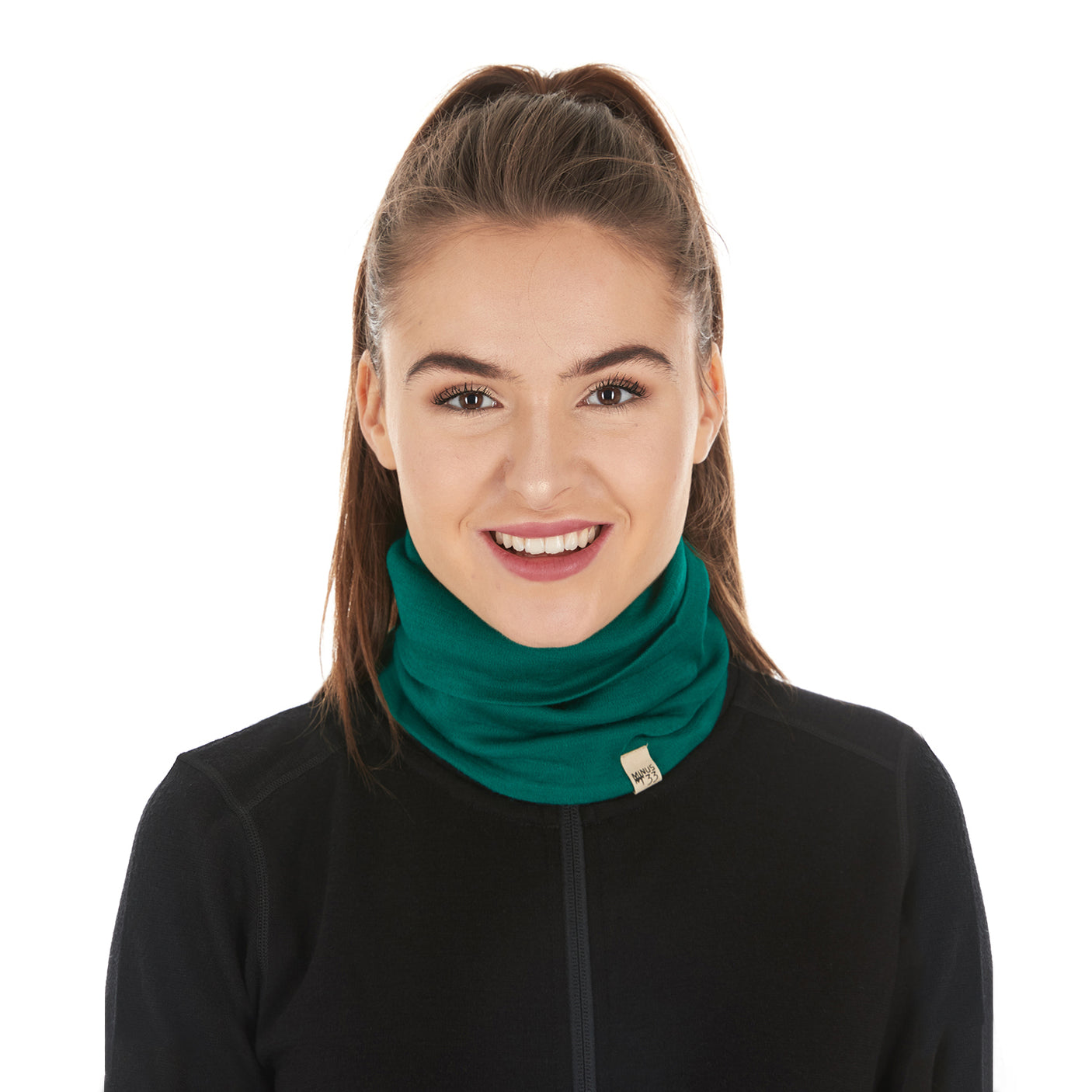 Minus33 Midweight - Neck Gaiter 100% Merino Wool in Emerald Green worn on a neutral background.