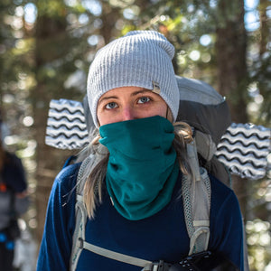 Minus33 Midweight - Neck Gaiter 100% Merino Wool in Emerald Green being worn in a forest.