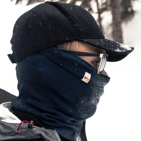 Minus33 Midweight - Neck Gaiter 100% Merino Wool in Navy Blue worn outside in the snow.