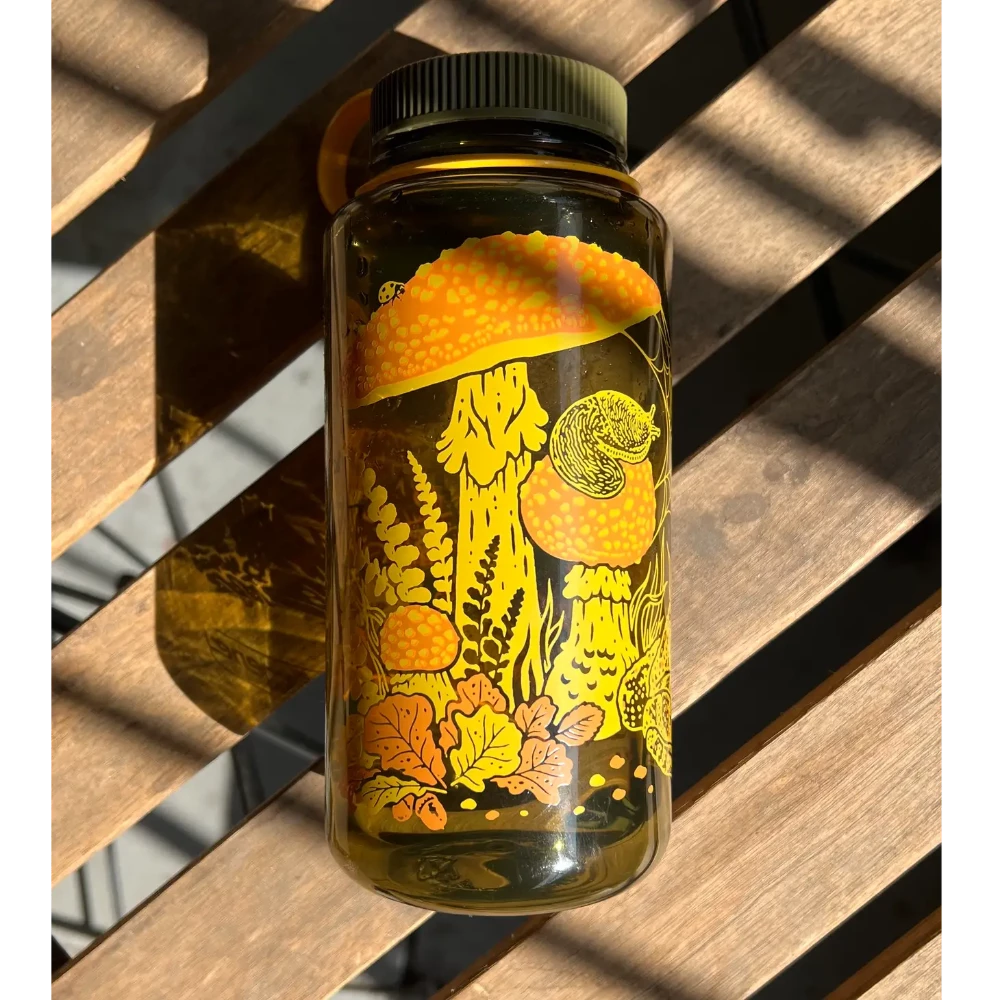 Mustard Beetle 32oz Nalgene bottle with the Toad & Mushrooms print features an orange and yellow print on a brown Nalgene bottle.