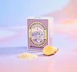 Box of Siesta Co. Ginger Sea Salt Flakes with a lemon and salt flakes on a gradient background