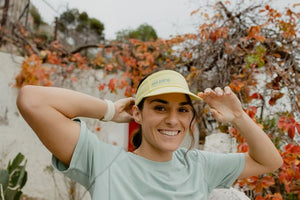 Janji AFO Hyperlight Visor worn by a woman outdoors.