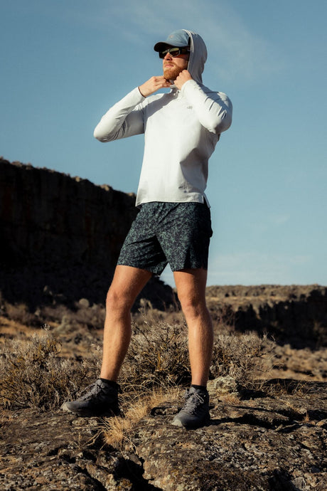 Outdoor Research men's Echo Hoodie sun hoodie in Pebble worn by a man hiker.