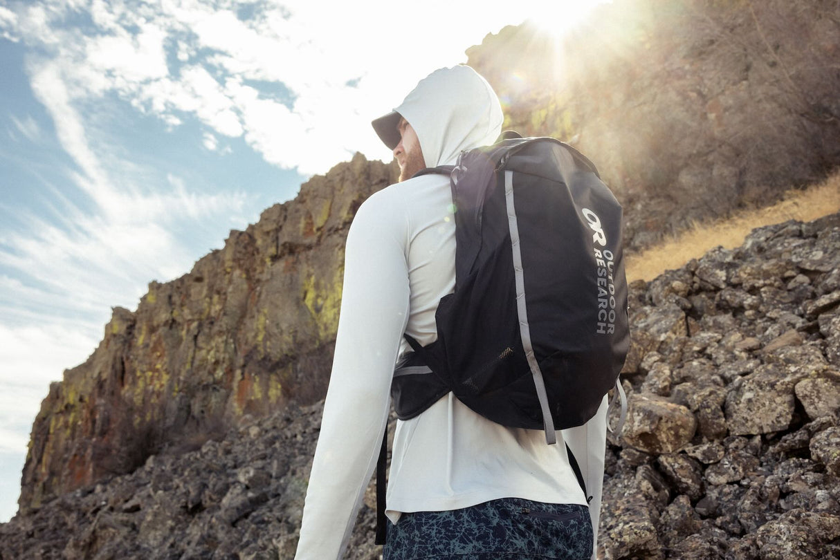 Outdoor Research men's Echo Hoodie sun hoodie in Pebble worn by a man hiker.