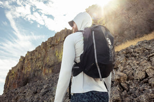 Outdoor Research men's Echo Hoodie sun hoodie in Pebble worn by a man hiker.