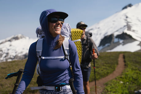 Outdoor Research Women's Echo Hoodie sun hoodie in Galactic worn by a woman hiker in the mountains.