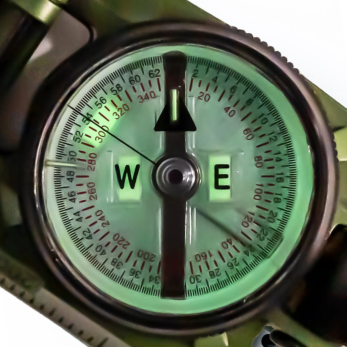 Close-up of a Brunton H-3 Tritium Lensatic Compass with a green glow on a white background