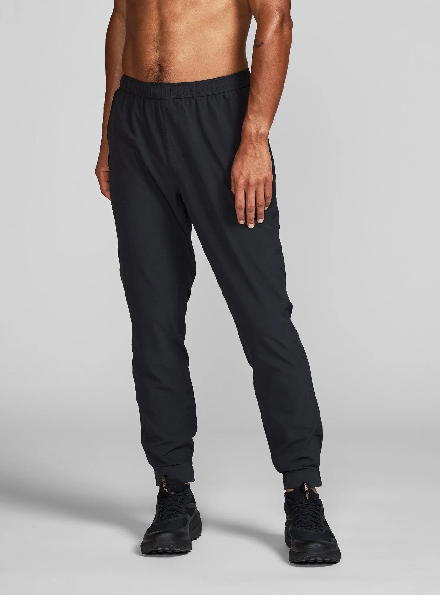 Janji Men's Transit Tech Pant in Midnight worn by a man on a neutral background.