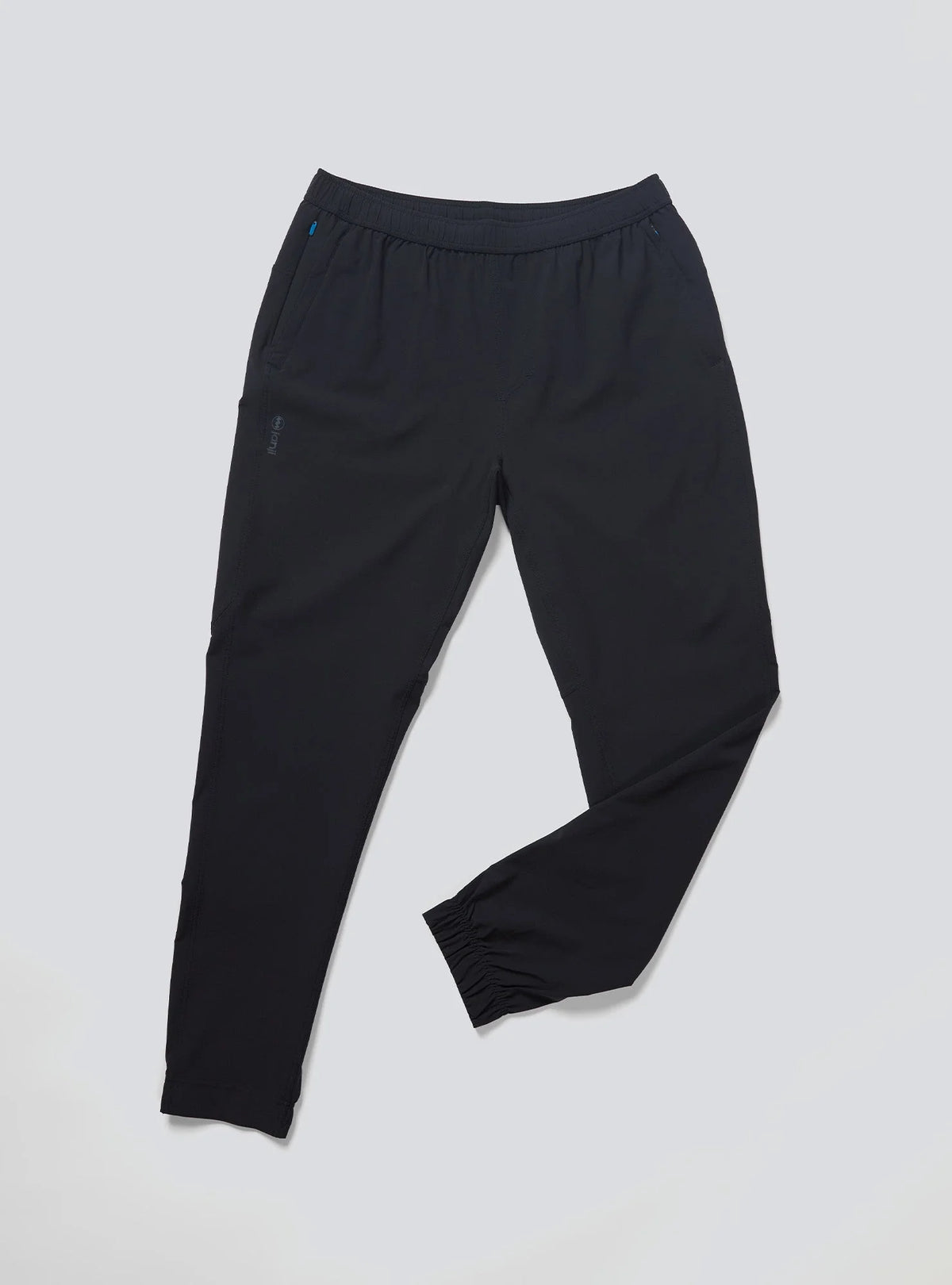 Janji Men's Transit Tech Pant in Midnight on a neutral background.