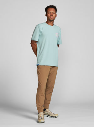 Janji's Circa Daily Tee in Destination Everywhere worn by a man on a neutral background.