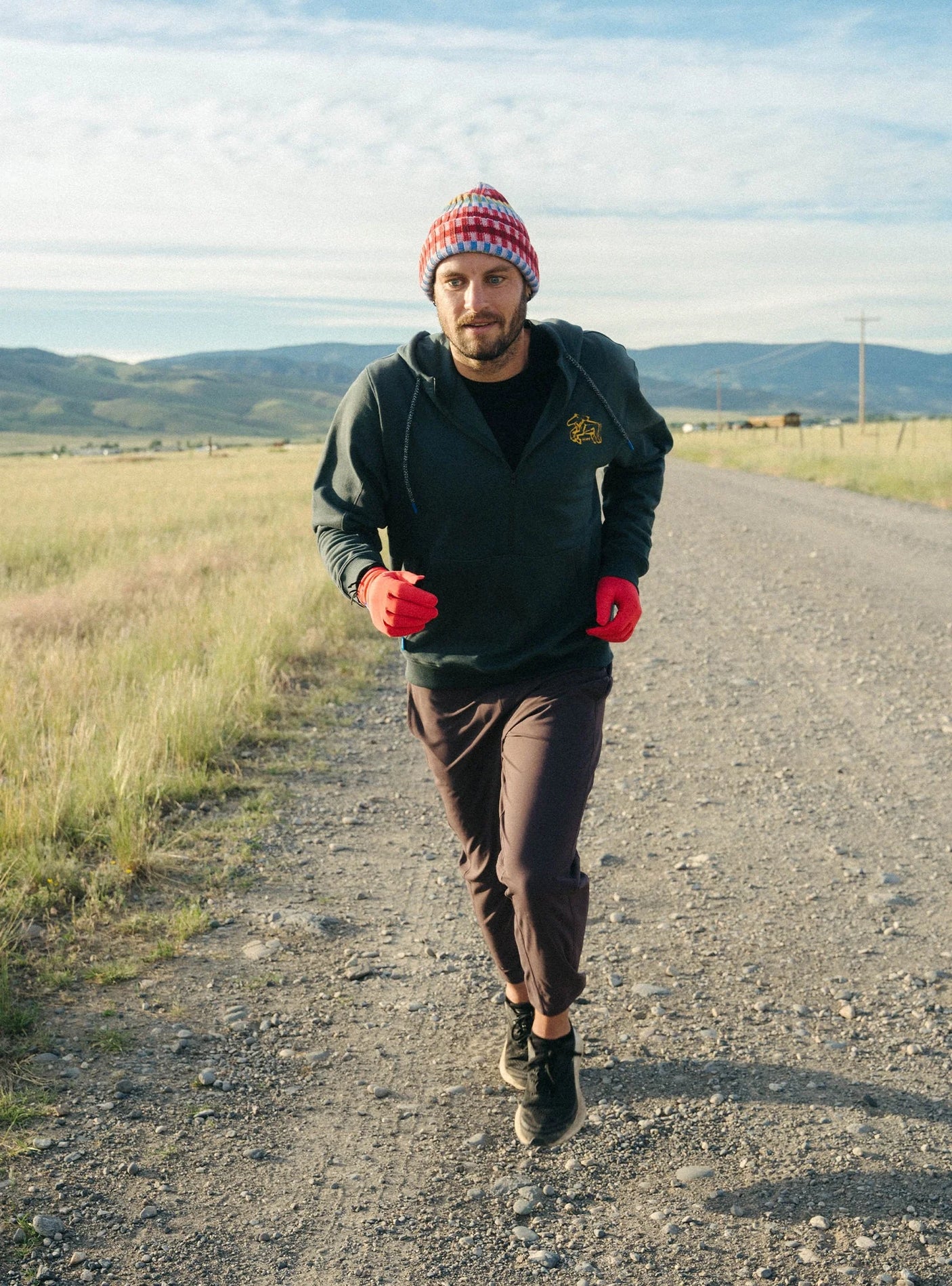 Janji Unisex Runaround Half-Zip Hoodie in Ridgeline Wild Horse being worn outdoors on a run.