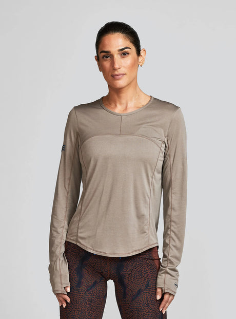 Janji W's Run All Day Long Sleeve in Silt worn by a woman on a neutral background.