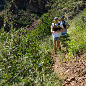 Ultimate Direction Xodus Vest in Fig Green being worn outdoors.