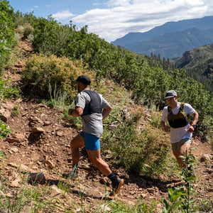 Ultimate Direction Xodus Vest in Fig Green being worn outdoors.