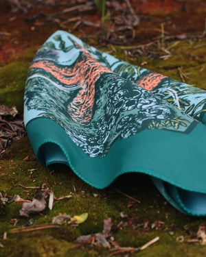 Alpinecho Tide Pool quick-dry bandana on a nature background.
