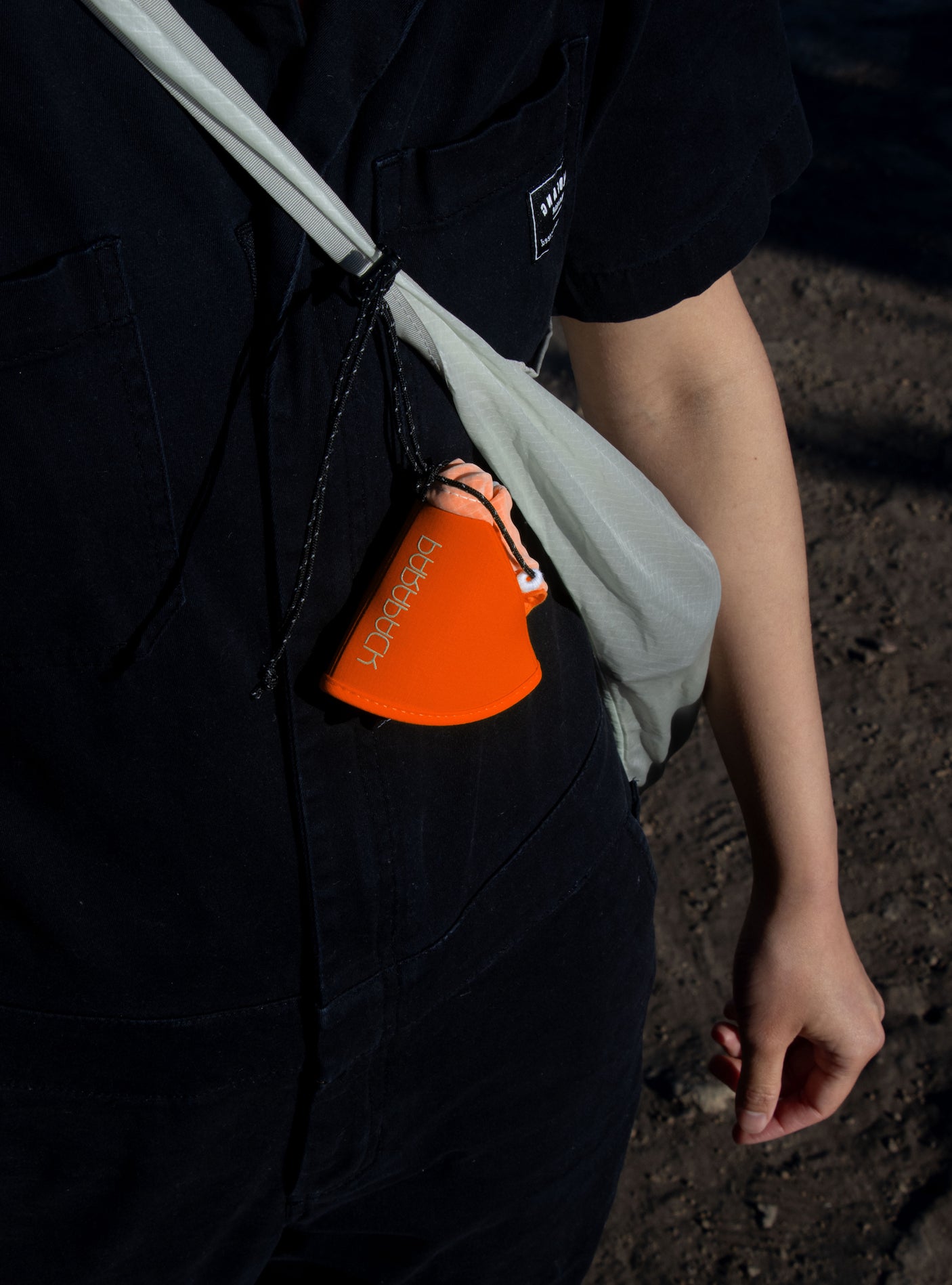 Parapack V-Cap in Redrock packed and being carried on a sling bag.