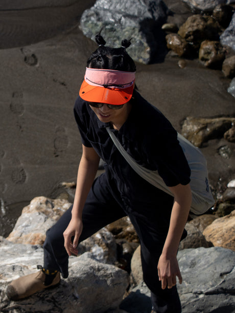 Parapack V-Cap in Redrock being worn by a woman hiking on the beach.