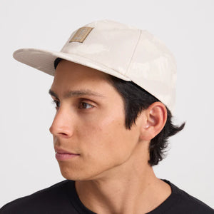 Man wearing a Roark Bless Up Trail Hat Strapback Hat in Fossil on a white background