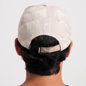 Person wearing a Roark Bless Up Trail Hat Strapback Hat in Fossil from behind on a light gray background