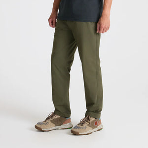 Person wearing Roark Layover Pro Traveler Pants in Military and patterned shoes on a white background