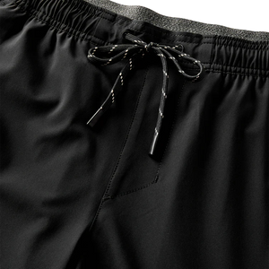 Close-up of Roark Serrano 7" Active Stretch Shorts in Black with drawstring on a dark background