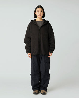 Person wearing a Snow Peak Flexible Insulated Zip Up Hoodie in Black and pants on a white background